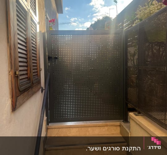 שער מתכת מחורר על גרם מדרגות חיצוני